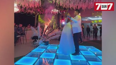 Des mariés continuent à danser au milieu d'un décor en feu
