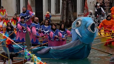 Versierde boten varen door Venetië voor aftrap carnaval