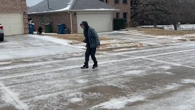 Amerikaan schaatst op beijzelde straat na hevige sneeuwstorm