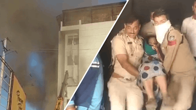 Hulpdiensten dragen vrouw uit brandend hotel in India