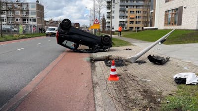 Auto raakt lantaarnpaal en belandt ondersteboven in Enschede
