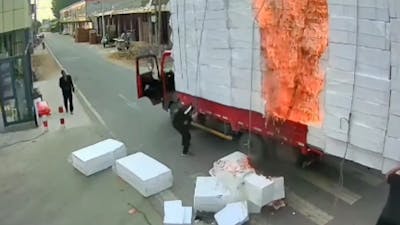 Chinezen duwen brandend piepschuim van vrachtwagen