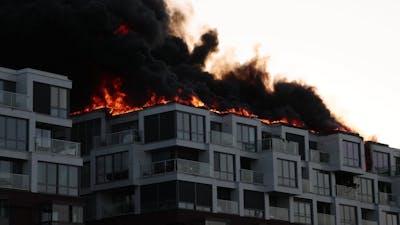 Vlammen slaan uit dak van Amsterdams appartementencomplex